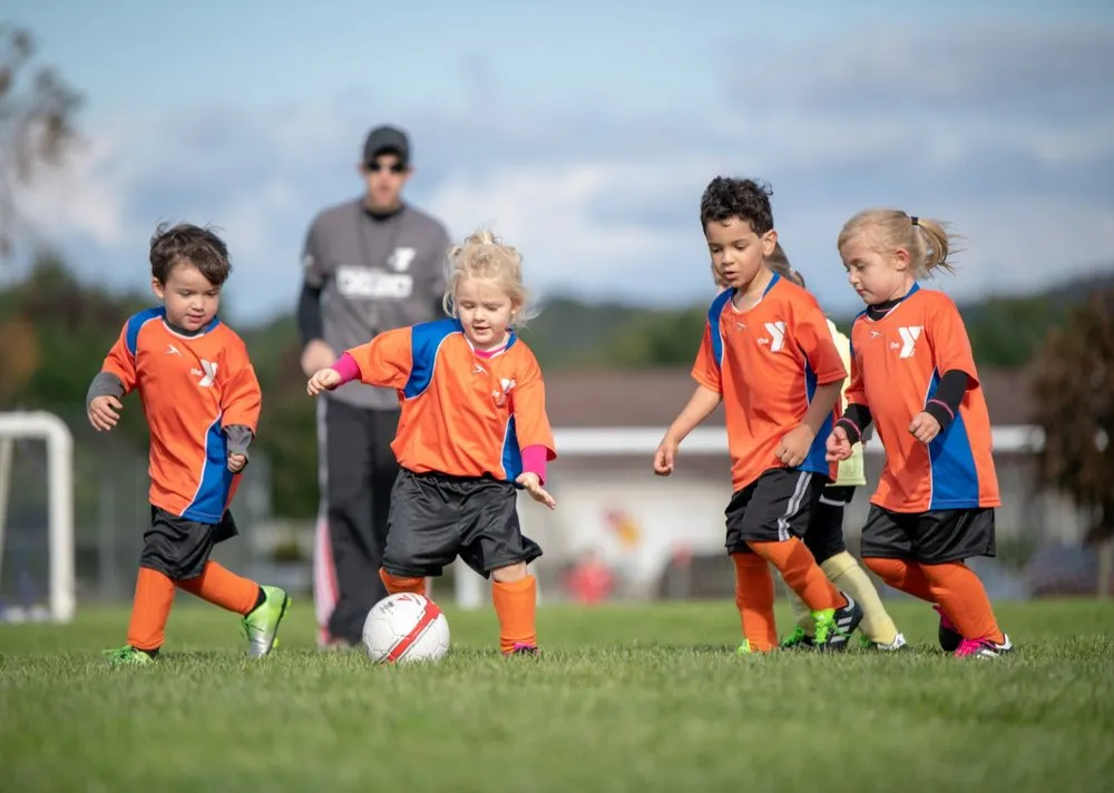 Preschool age kids playing soccer