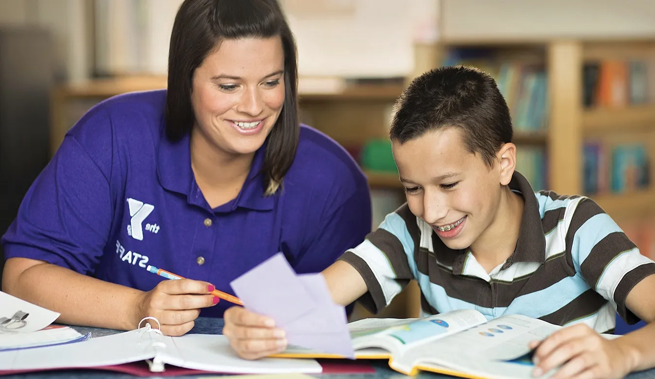 Female counselor tutoring young boy